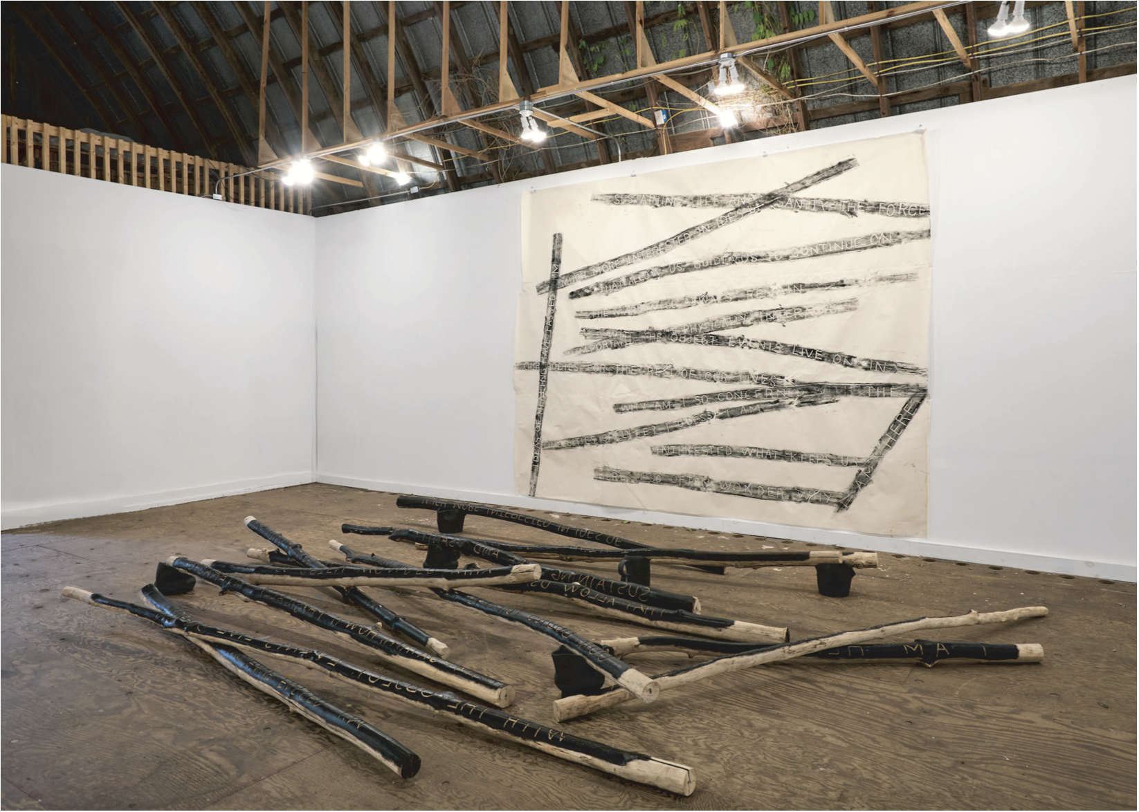 Empty room with branches laid out on floor matching print made from branches on canvas on wall