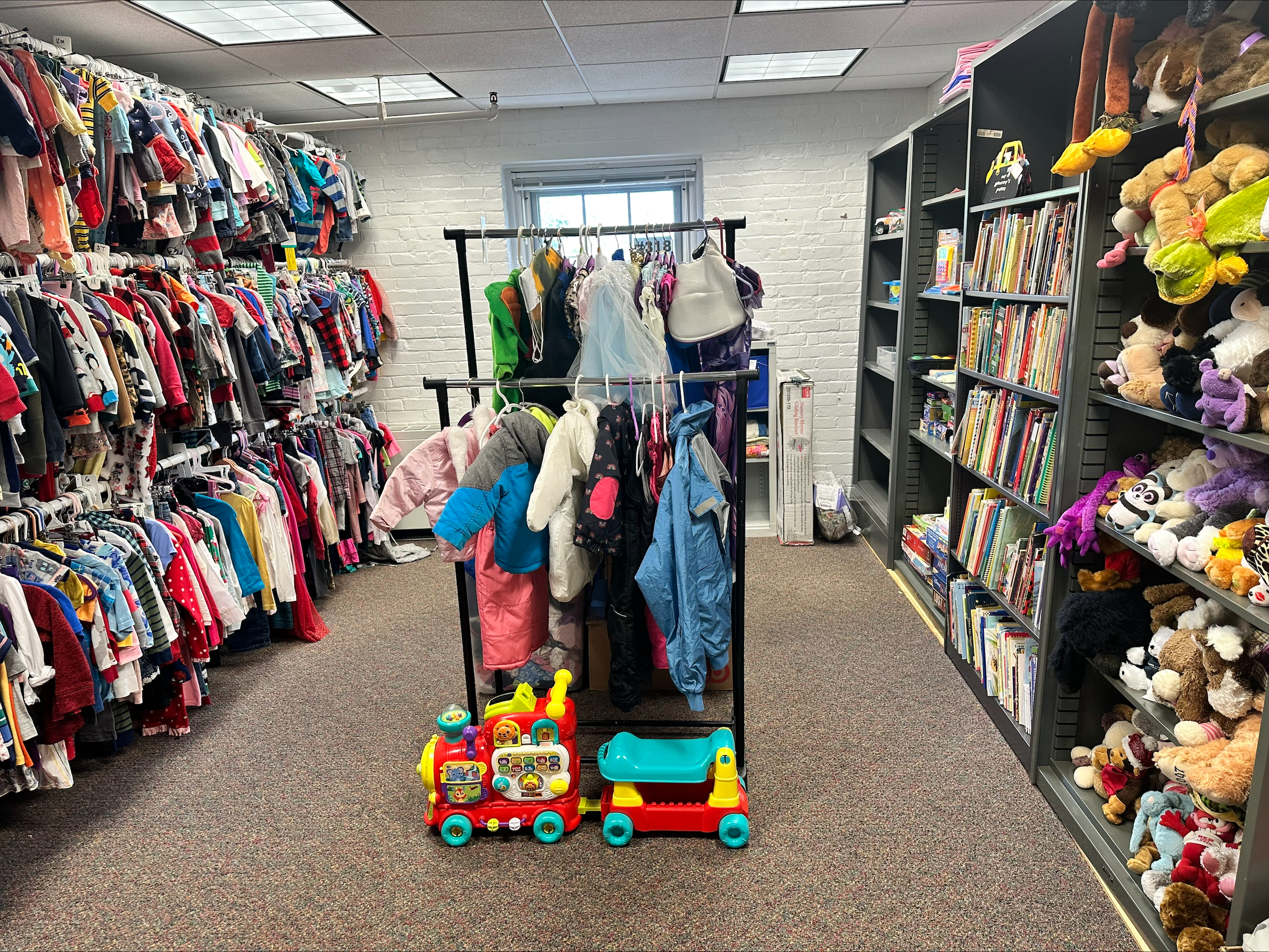 room with children's clothes, toys, stuffed animals and books