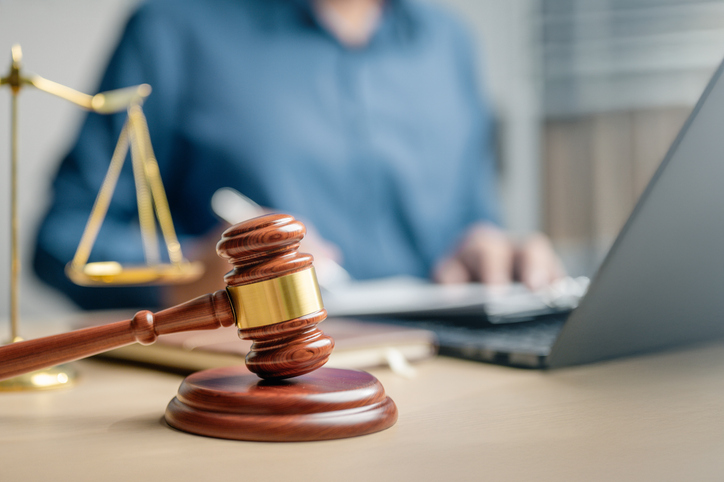 person working on laptop behind gavel