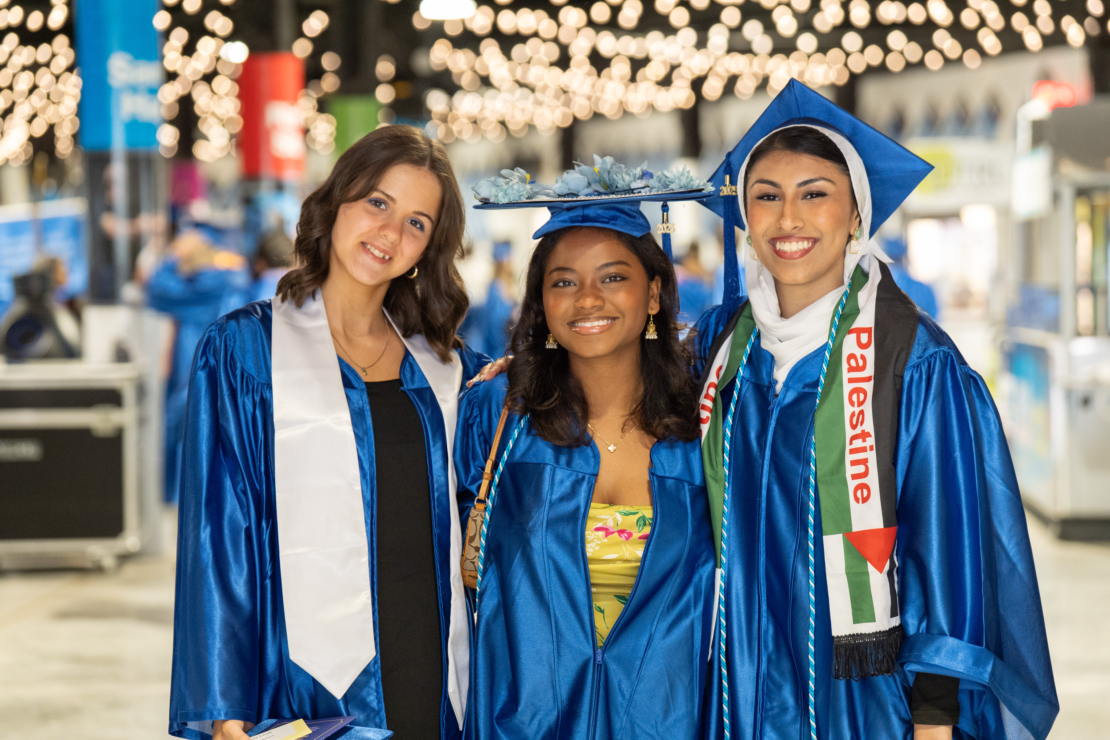 group of three graduates smile
