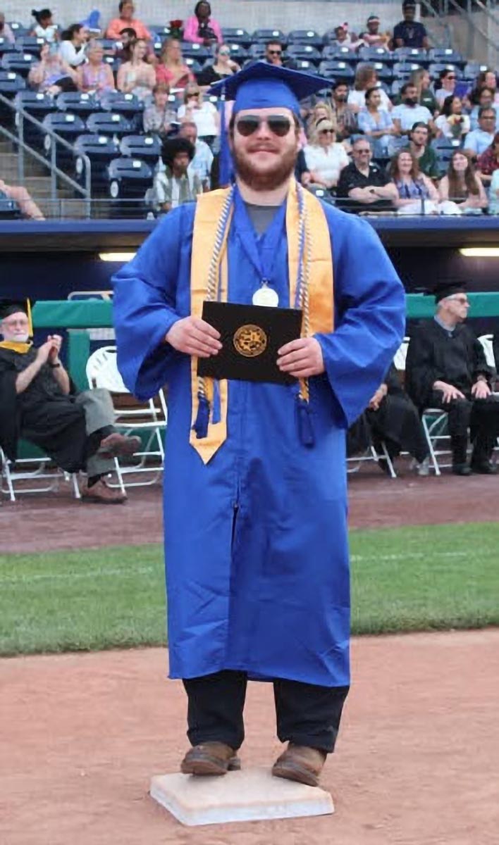A graduate poses during the commencement ceremony.