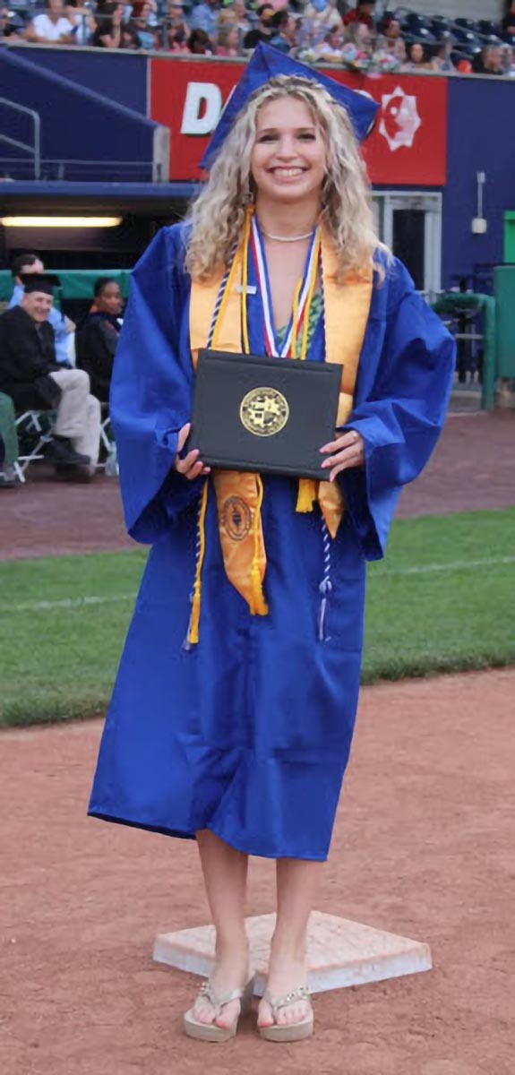 A graduate poses during the commencement ceremony.