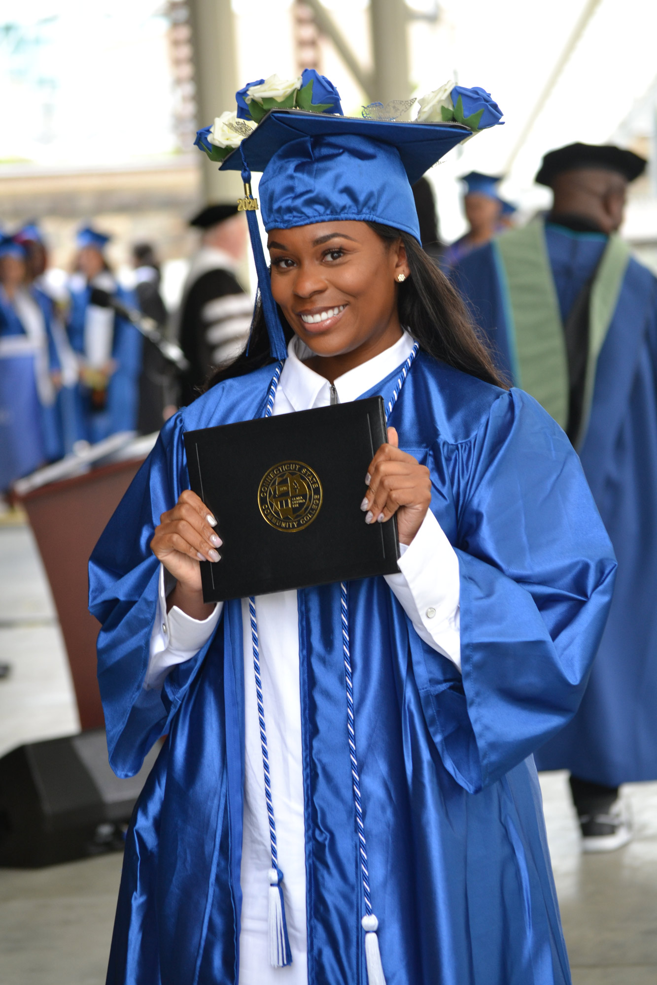 smiling female graduate holds up diploma