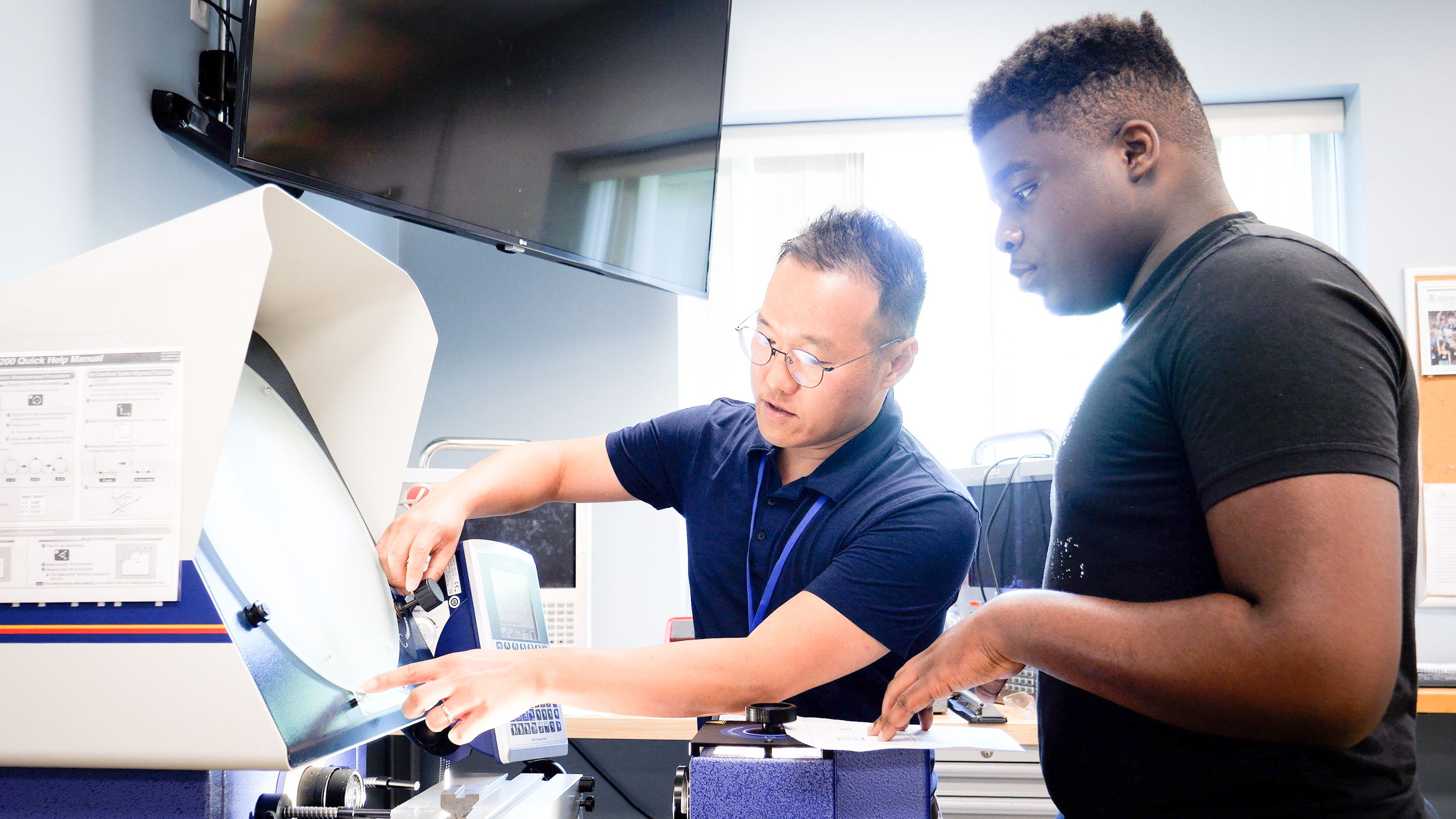 Professor shows student how to use machine