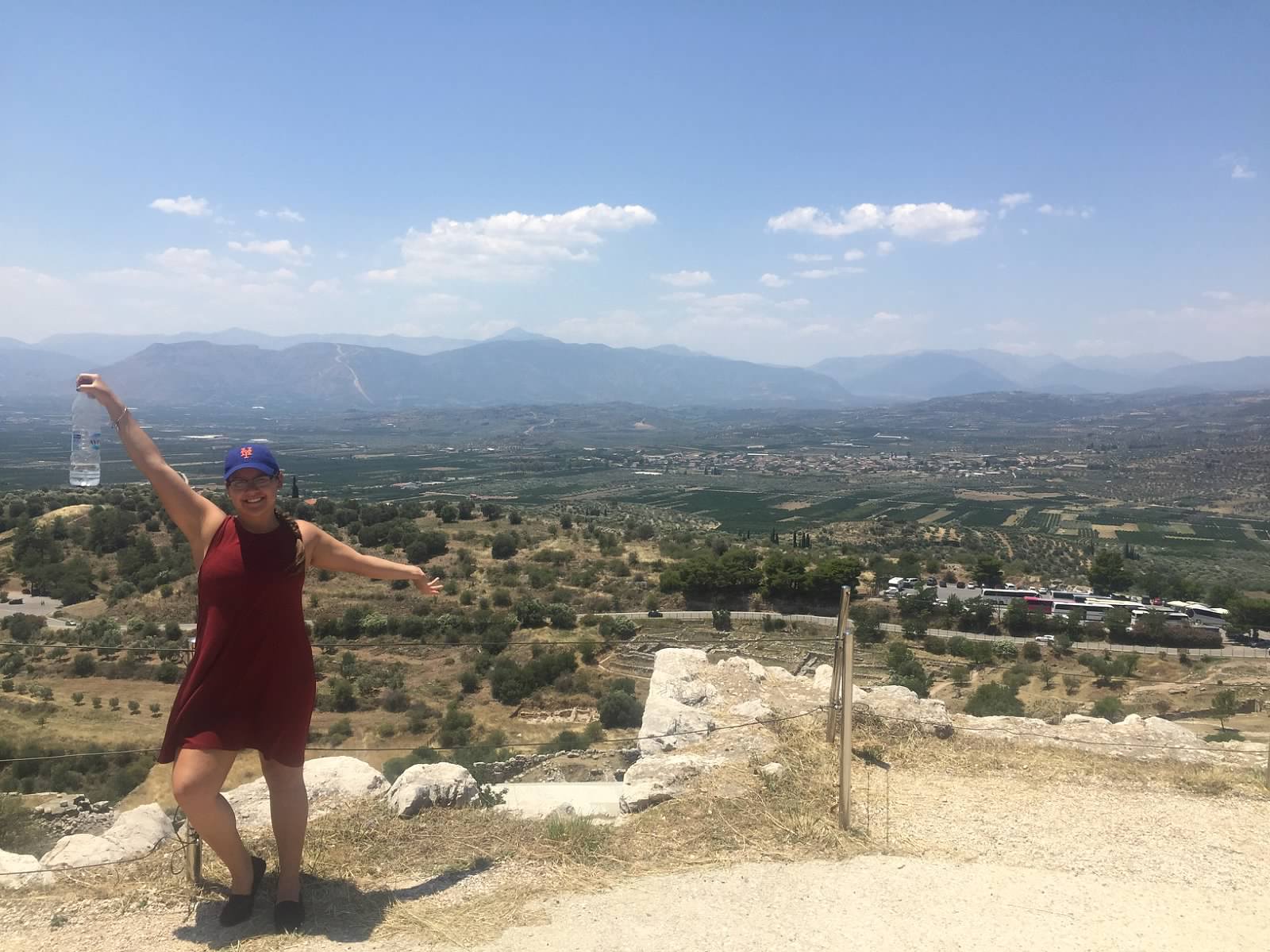 student poses in front of Grecian landscape