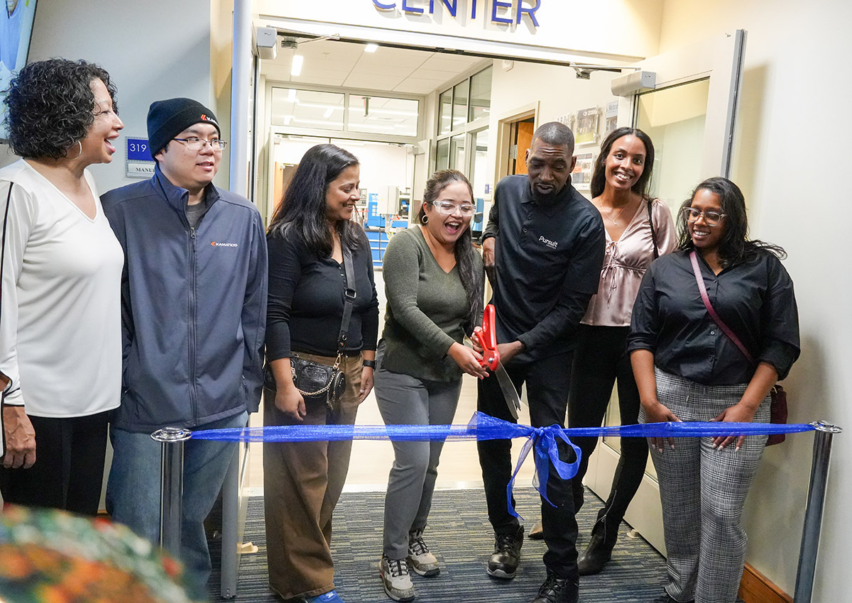 ACapital manufacturing students and alumni are shown cutting the ribbon for the new Manufacturing Center.