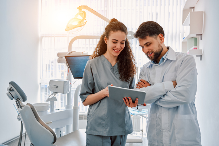 dental assistant shows dentist chart