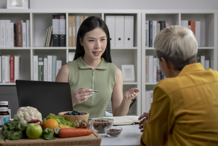 dietician at desk talks to client