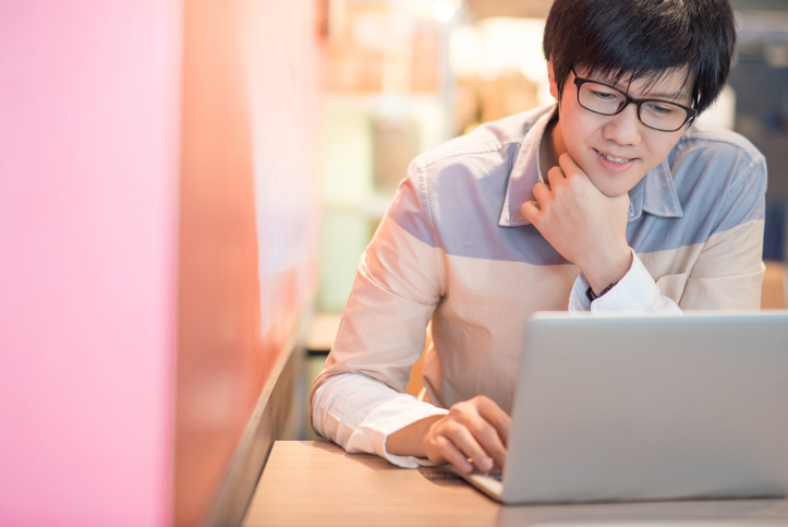 Young Asian man working with laptop computer