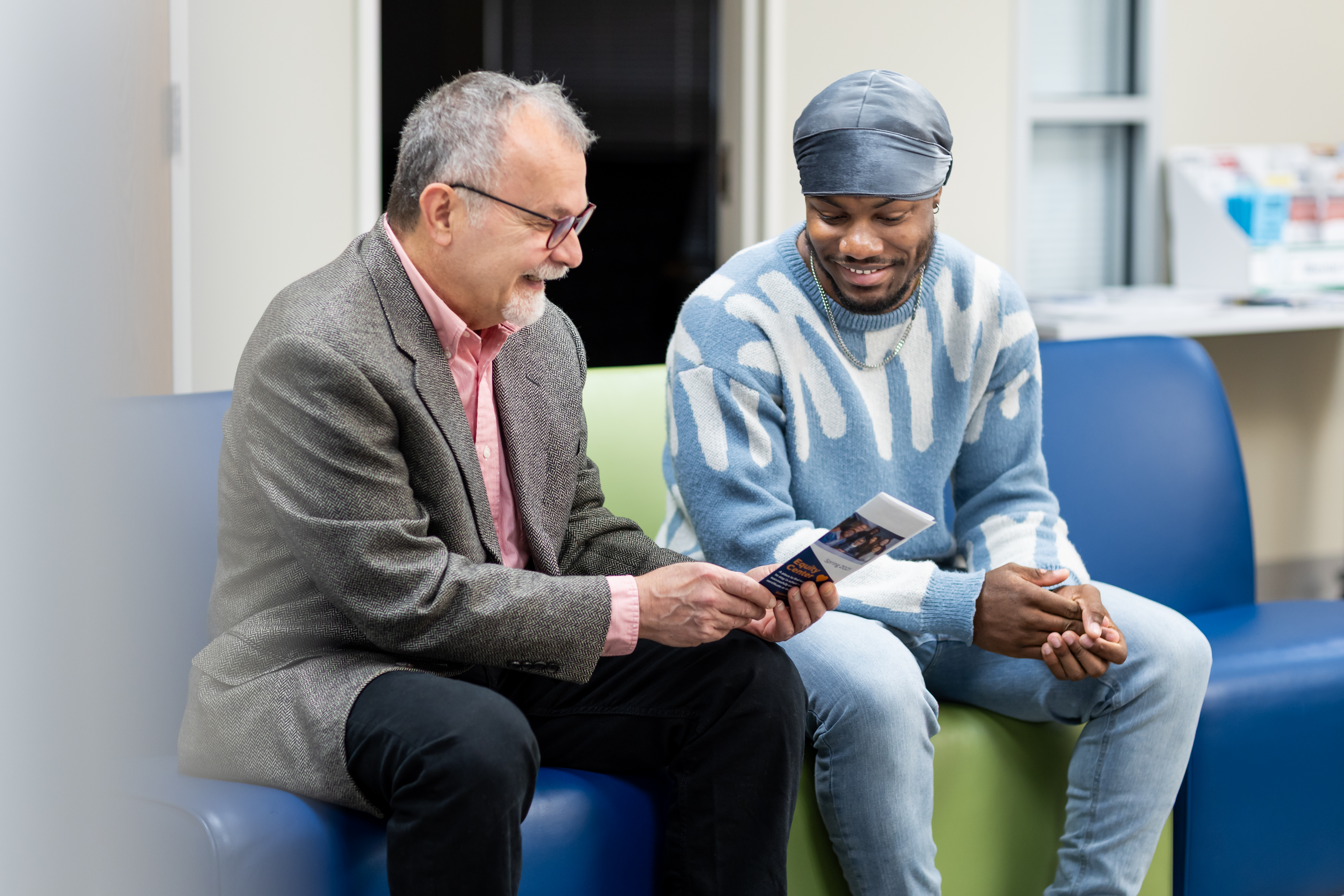 Professor shows student brochure at Capital campus.