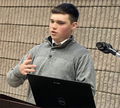 Dante Petruzziello speaks at podium during academic convivium