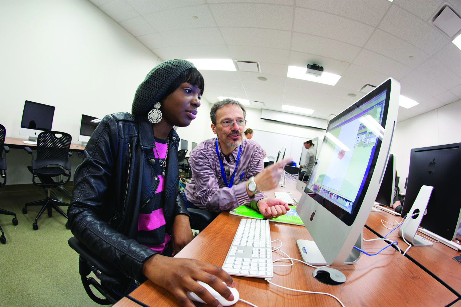 Professor helps student on MAC computer