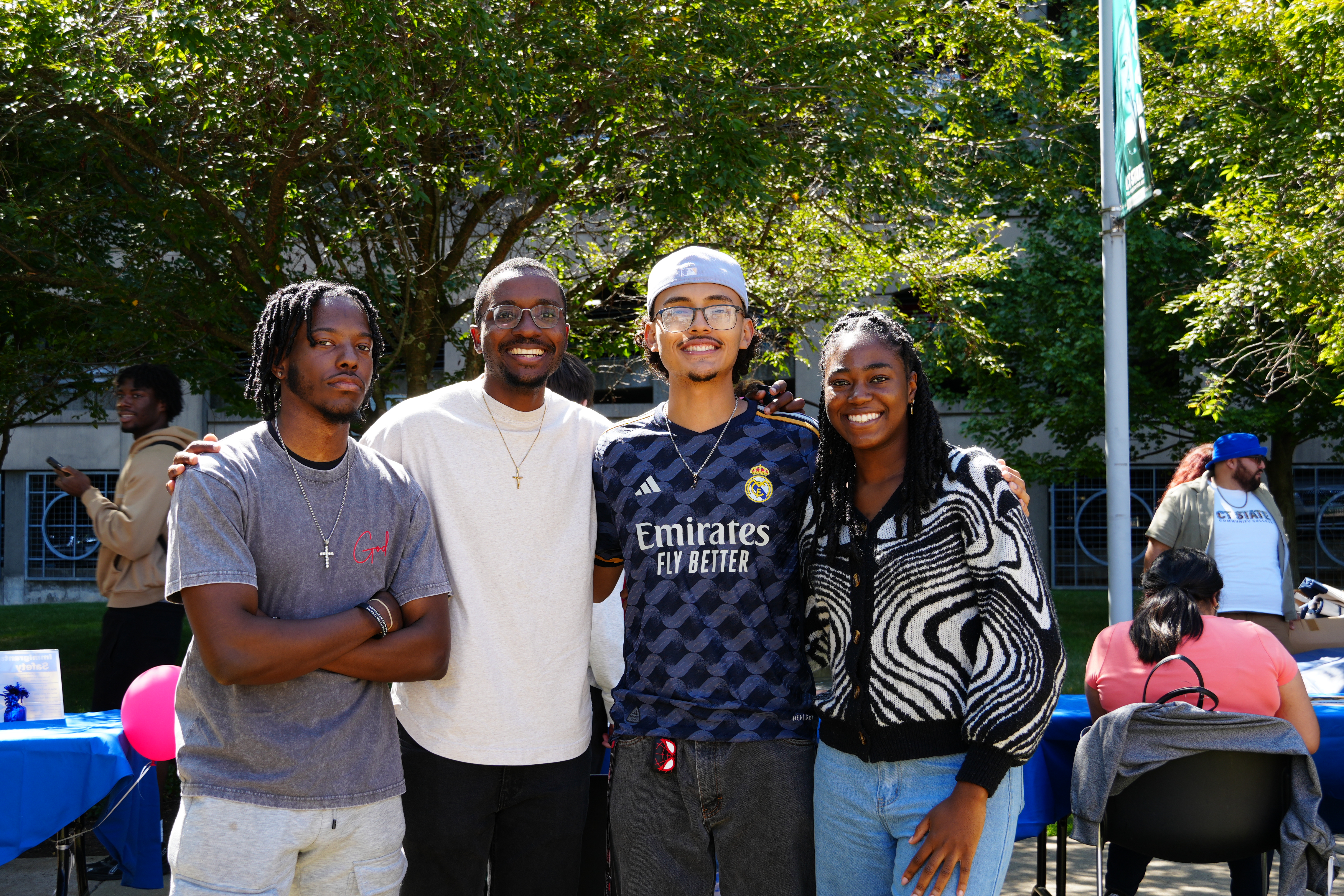 group of four students smile at camera