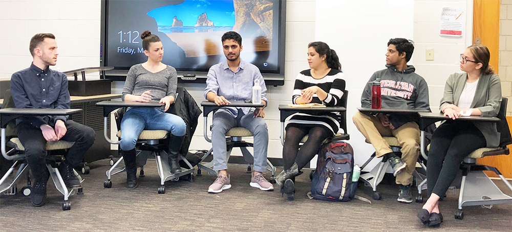 group of six honors students gather in a classroom for a discussion