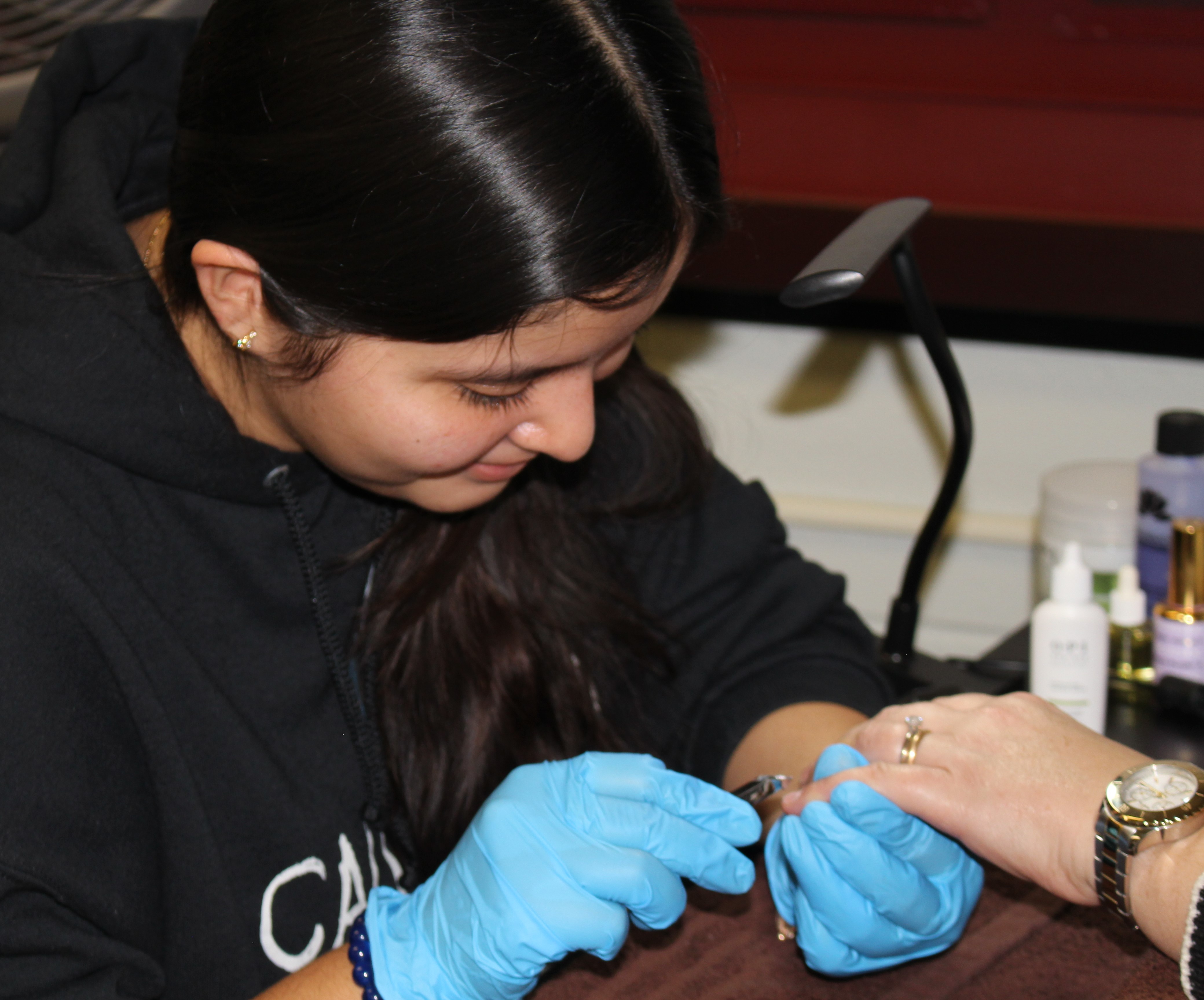 Esthetician student paints customer's nails