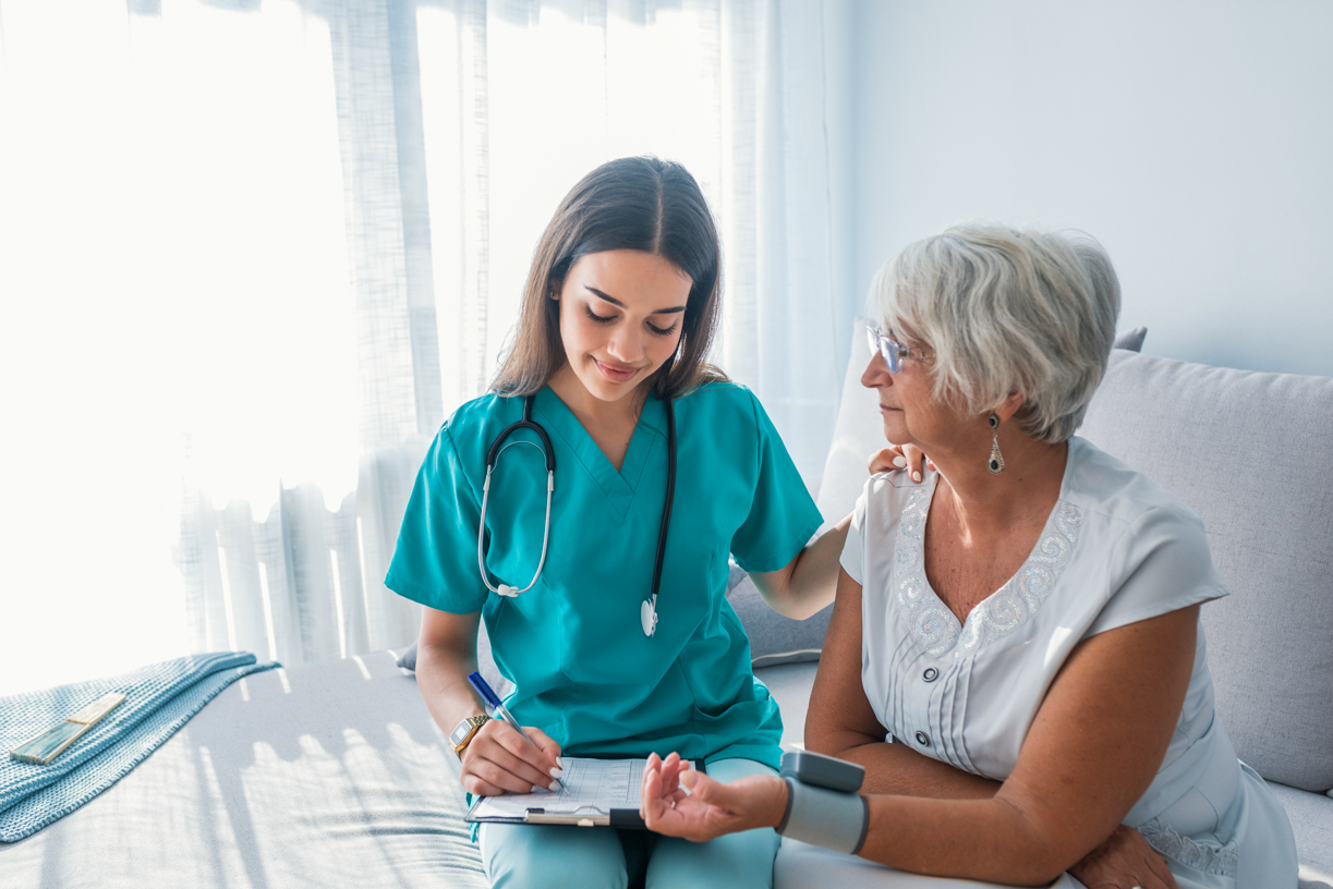 health care worker helps patient fill out paperwork