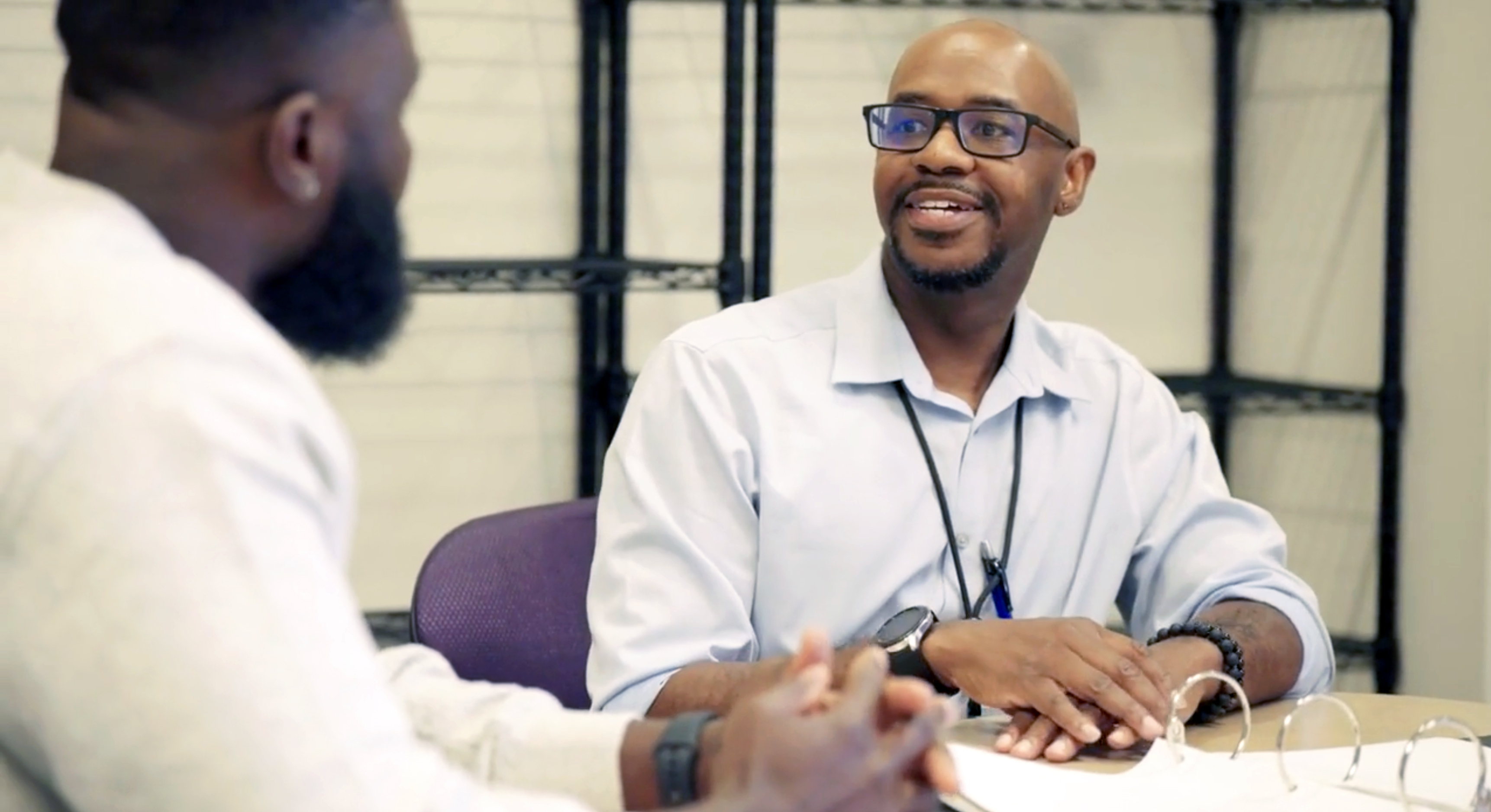 A doctor is consulting someone seated at a desk