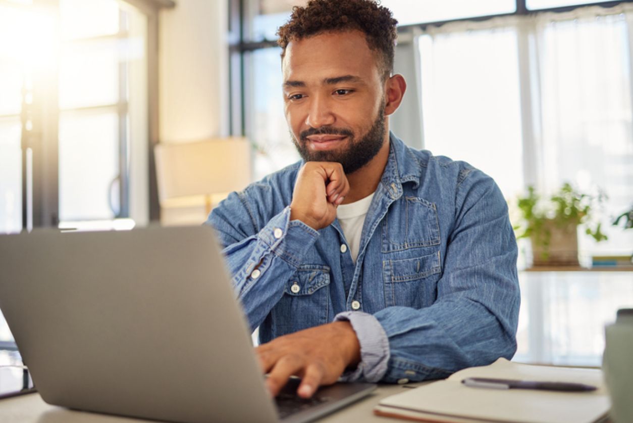 man looks at laptop