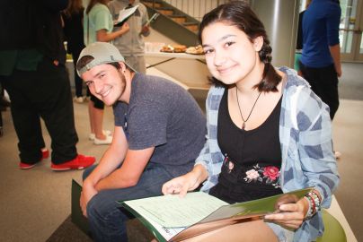 smiling students sit together in common area