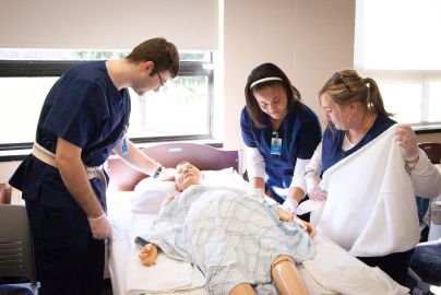 students in lab work together to cover patient.