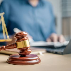 person working on laptop behind gavel