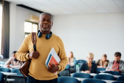 Senior citizen stands in classroom