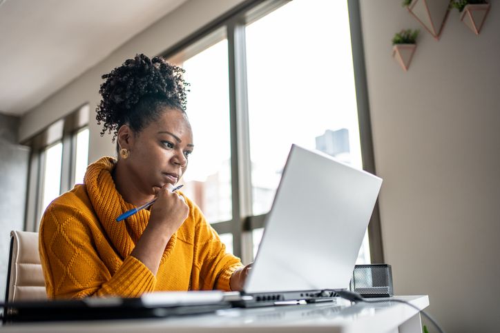 woman looks at computer screen in concentration
