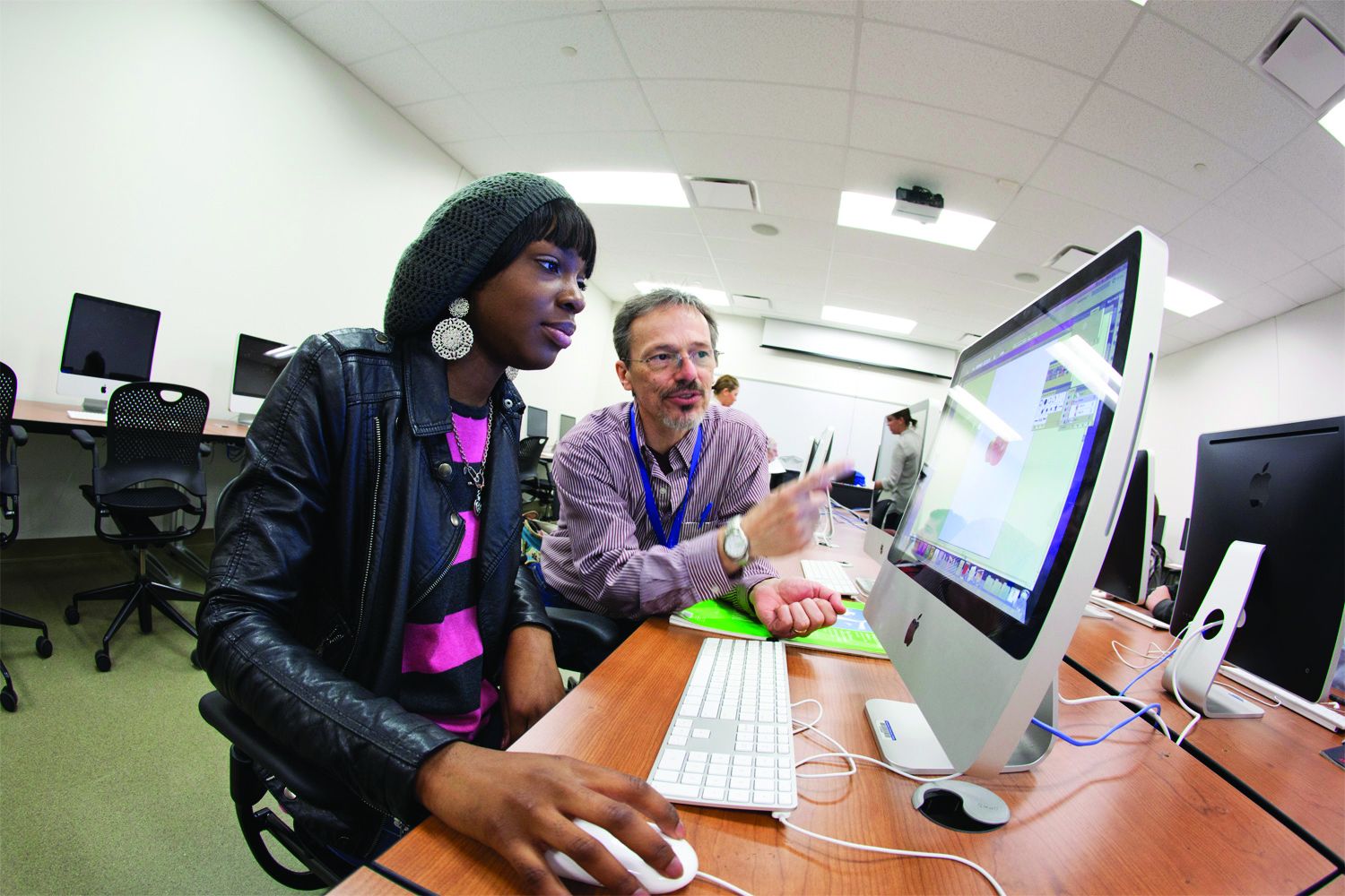 Professor helps student on MAC computer