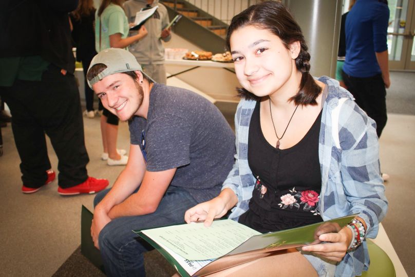 smiling students sit together in common area