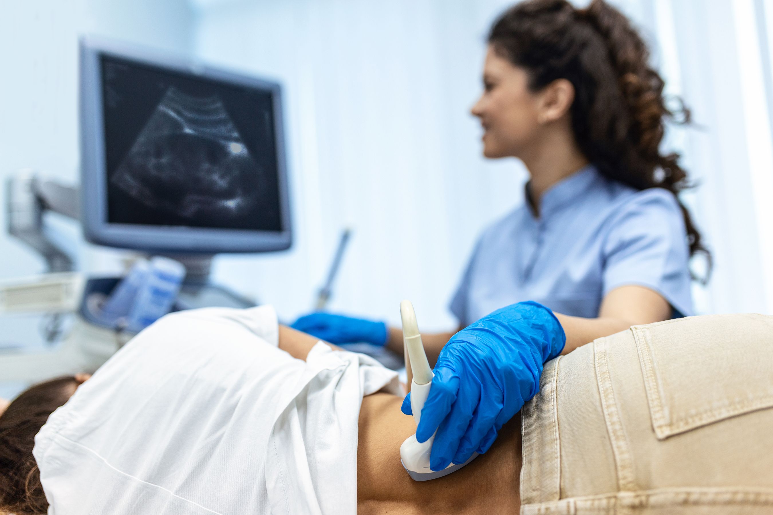 sonographer performs ultrasound on patient
