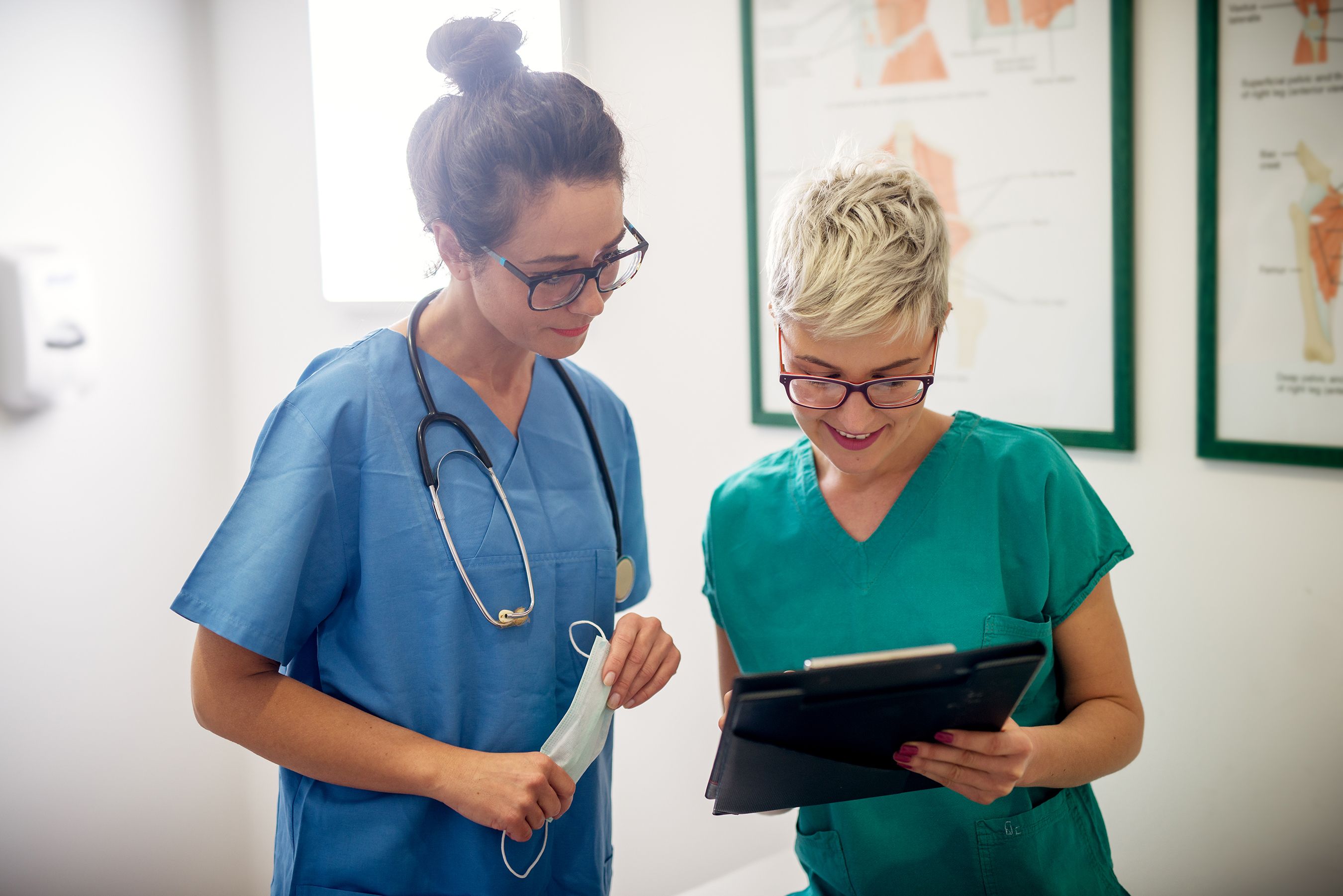 two female nurses review patient chart together