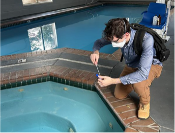 Person tests water in pool