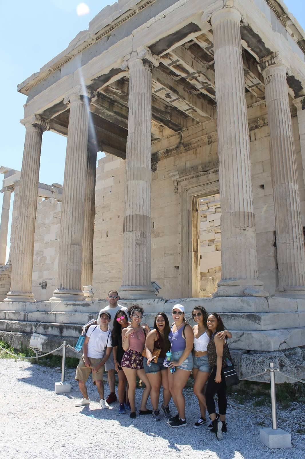 group of students pose in front of monument