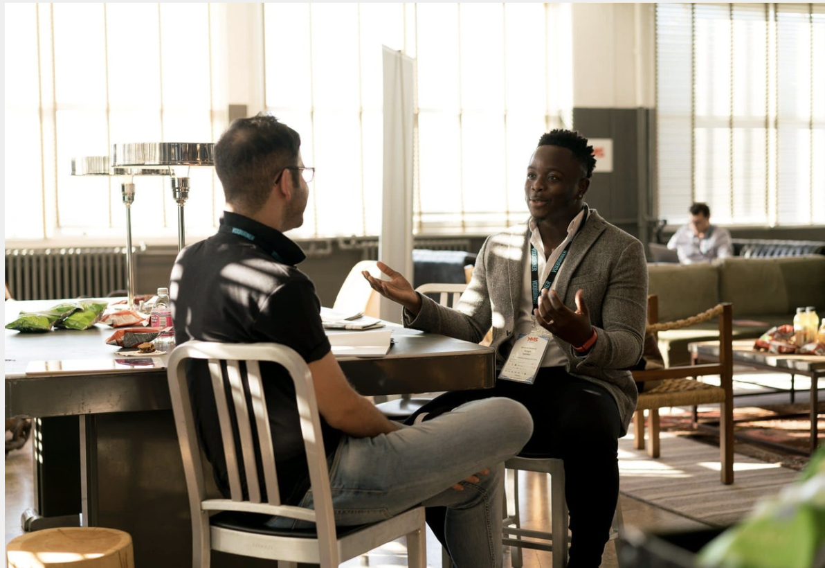 two men sit across from each other talking