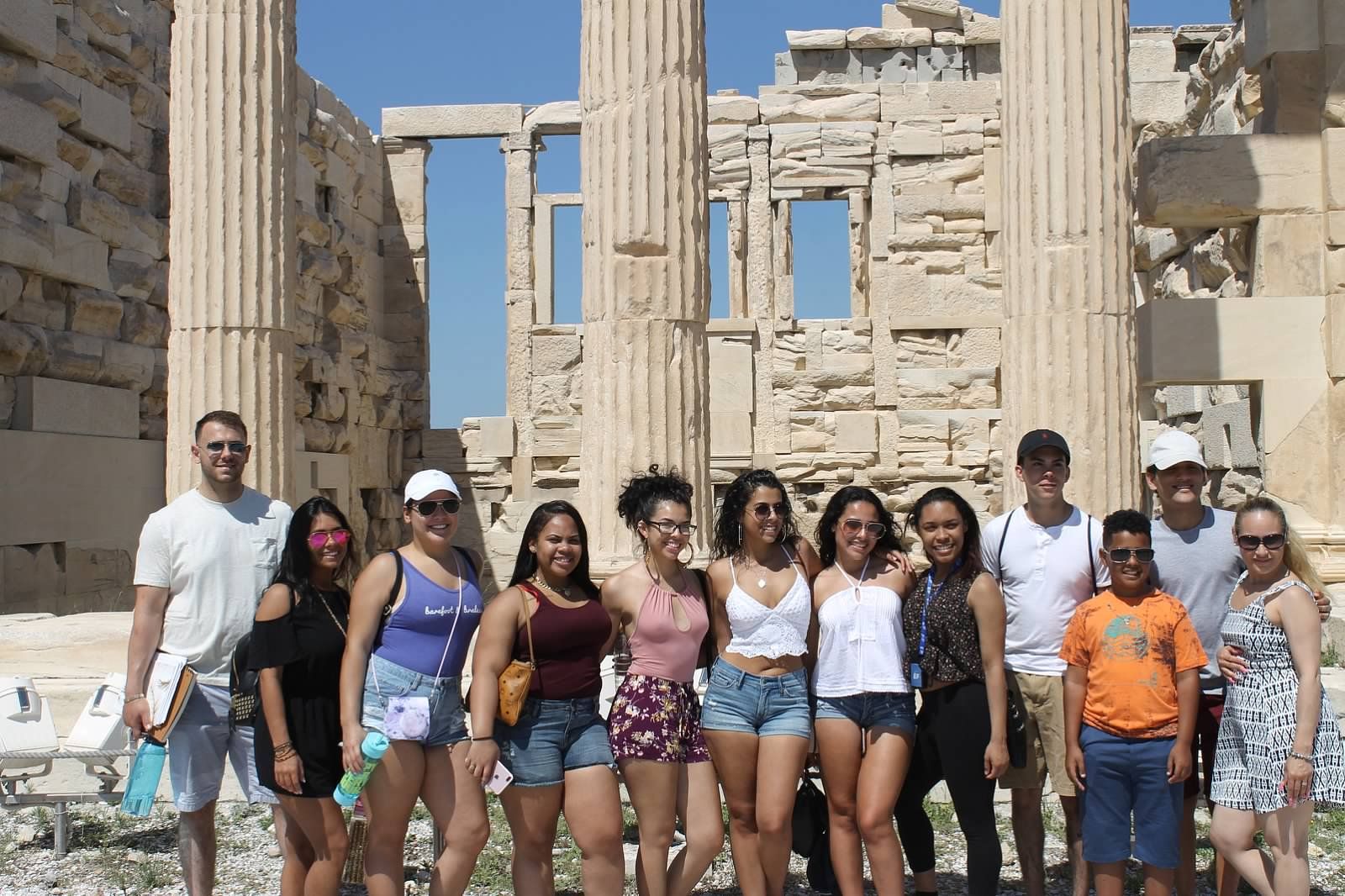 group of students pose in front of monument