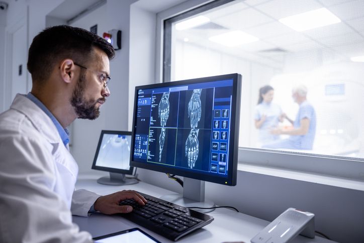 technician reviews scans on computer screen