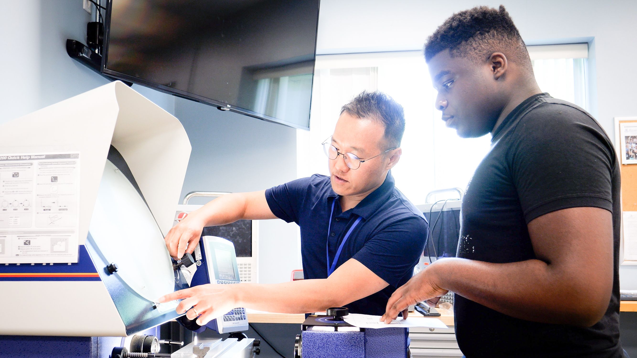 Professor shows student how to use machine