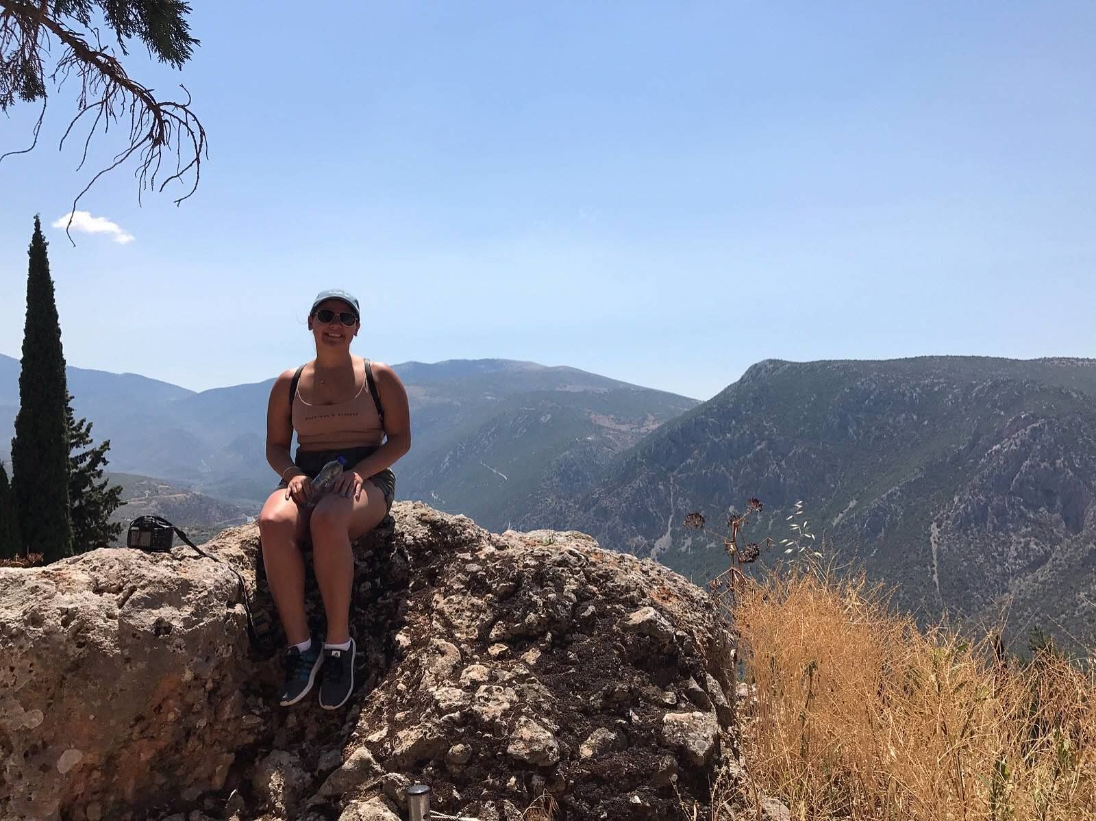 woman sits on rock