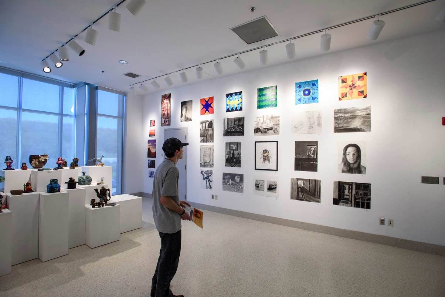 man looks at artwork in gallery