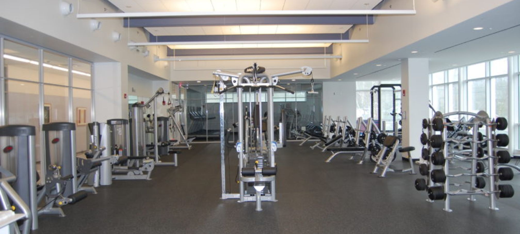 Norwalk fitness center shows equipment and weights lining brightly lit workout room