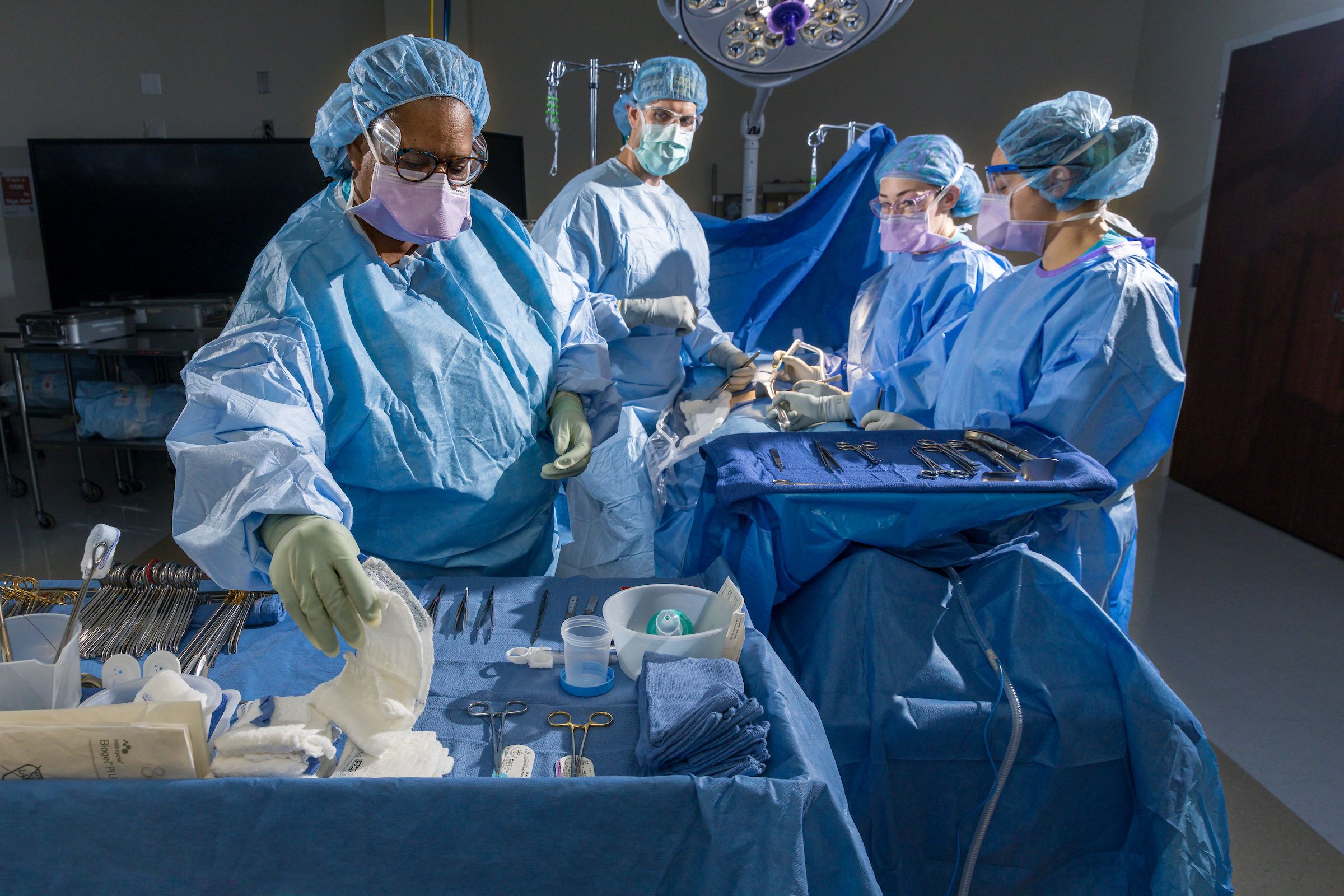 Group of surgical technology students work in surgical lab.