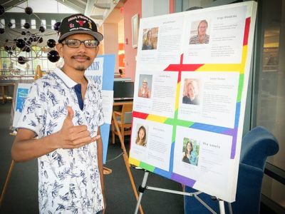 Tunxis Mentee stands in front of presentation board