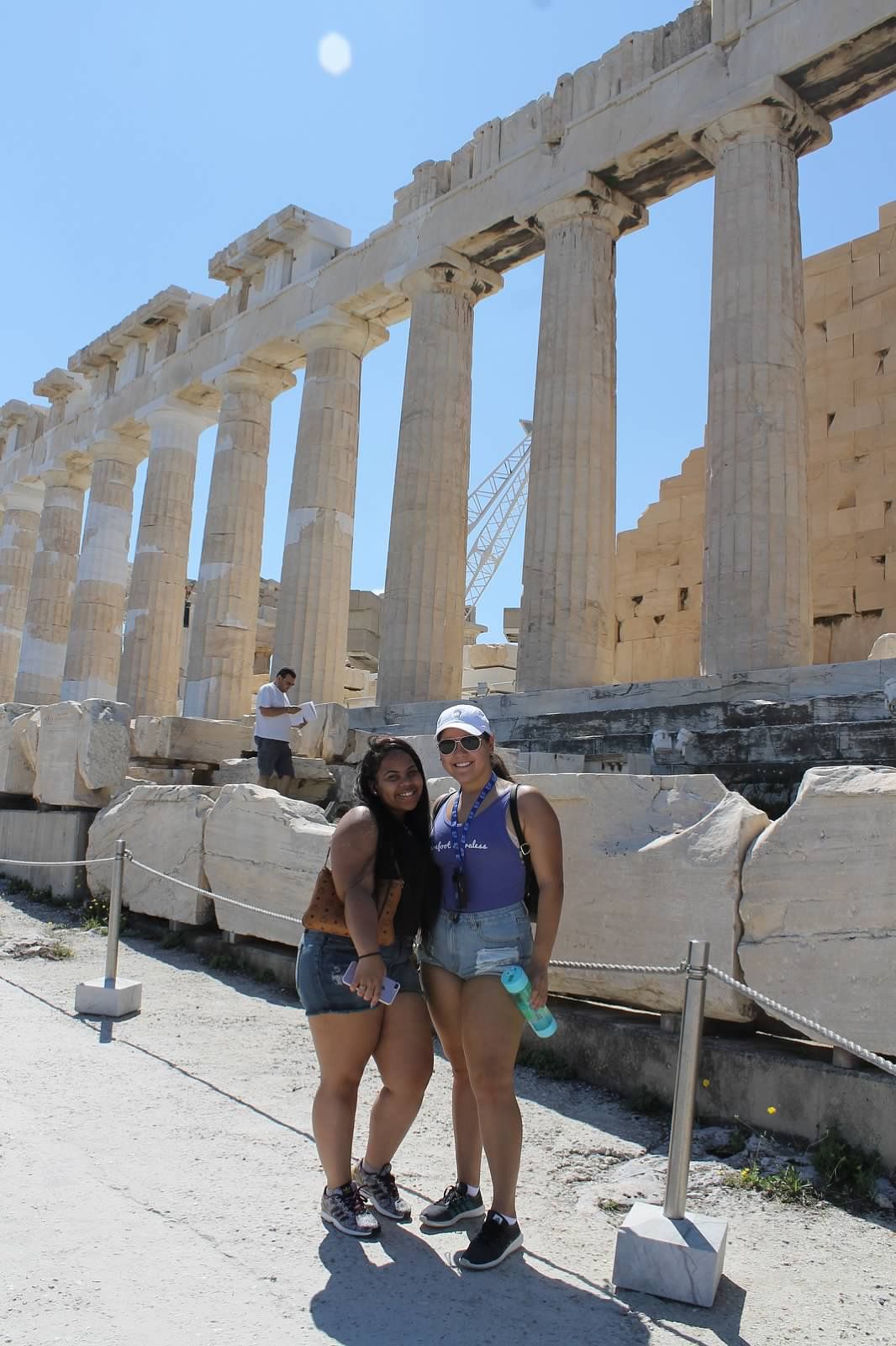 two students pose in front of monument