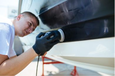 man works on side of boat