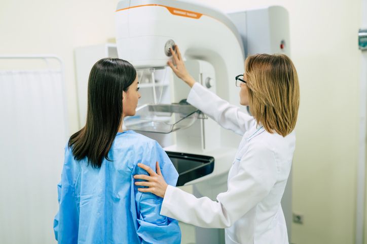 technician prepares patient to perform mammography