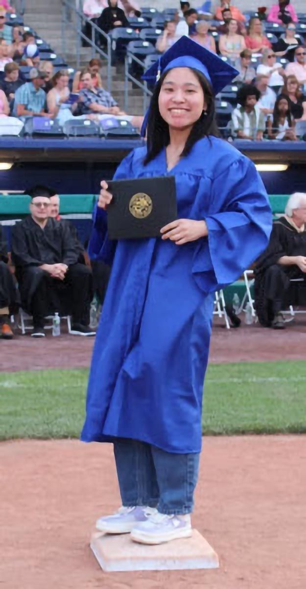A graduate poses during the commencement ceremony.