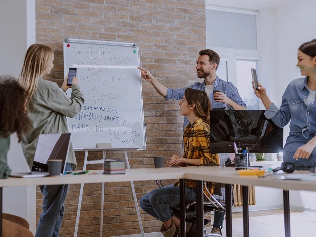 group of buesiness people work together on whiteboard