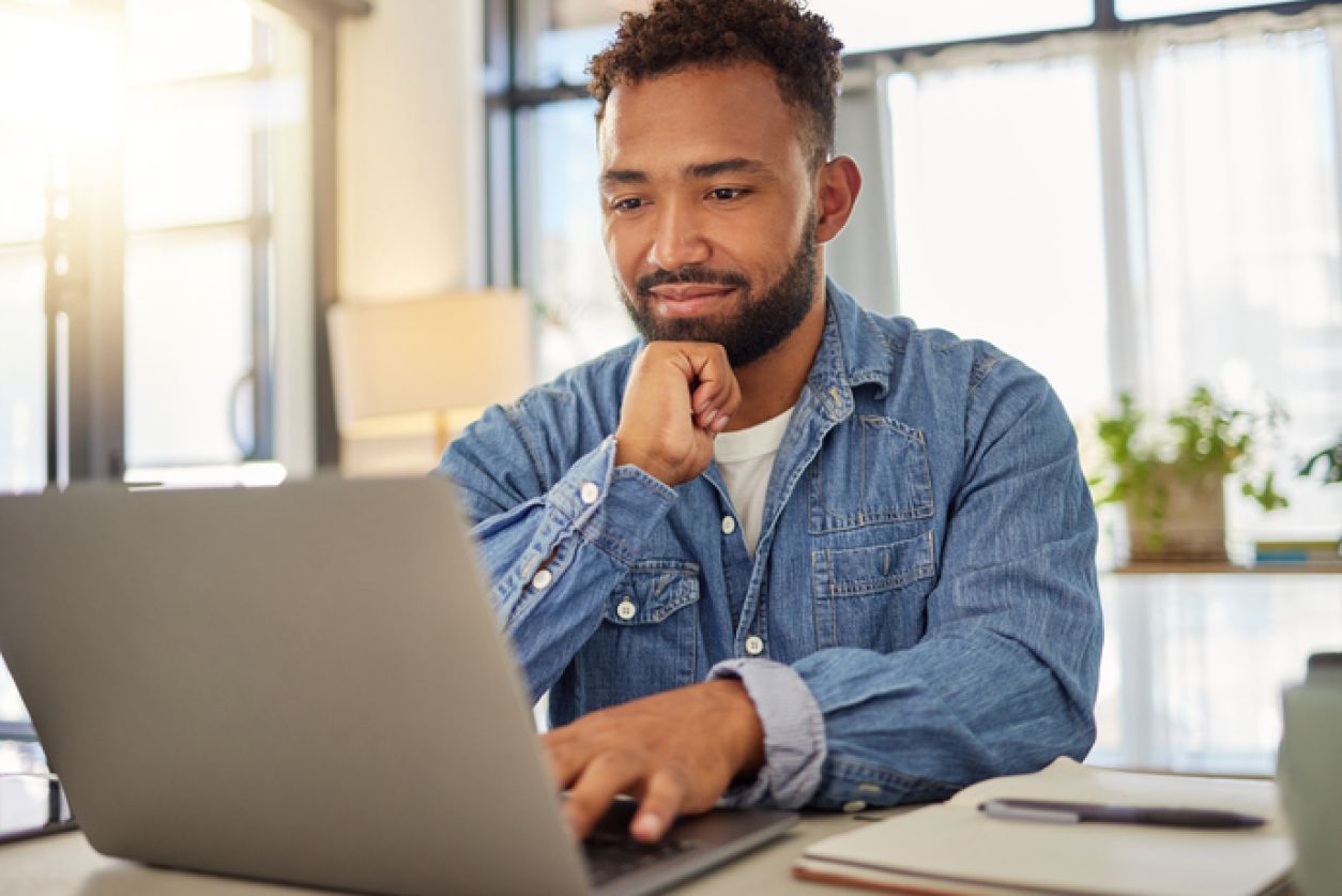 man looks at laptop