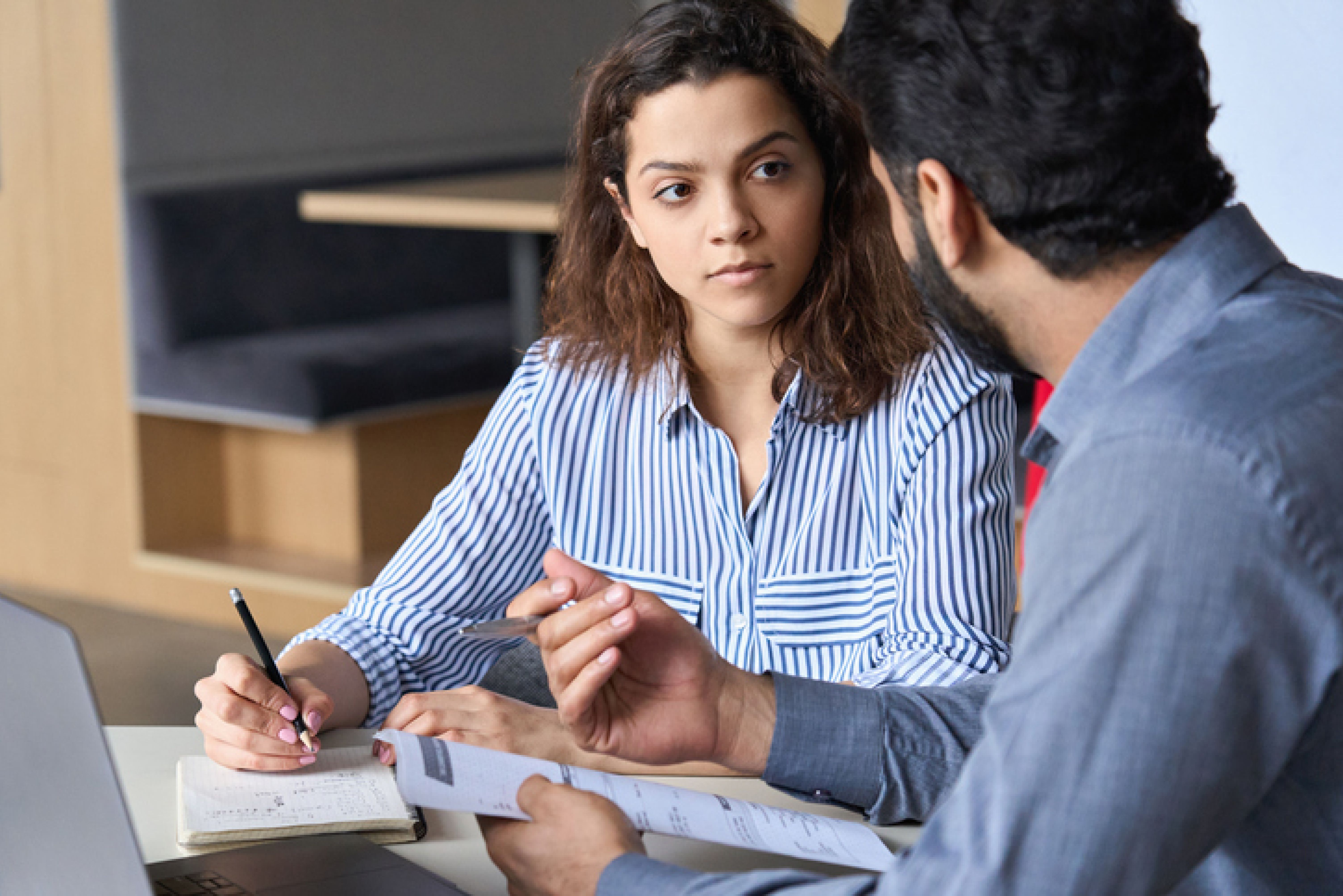 woman looks at man as they fill out paperwork together