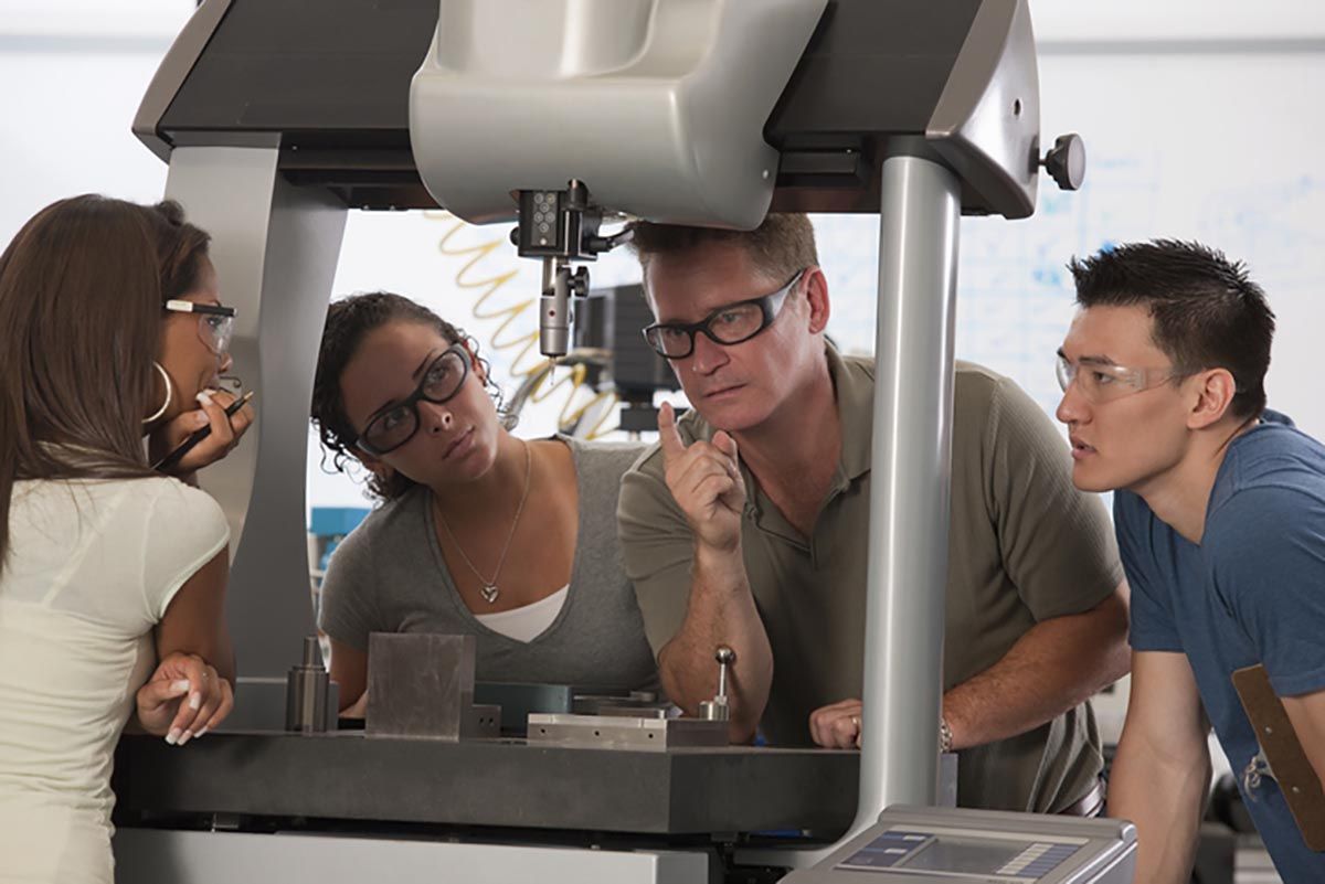 Four people working at machine